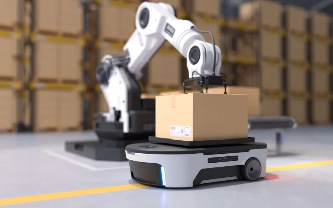 Robot arm loading a box onto an autonomous mobile robot